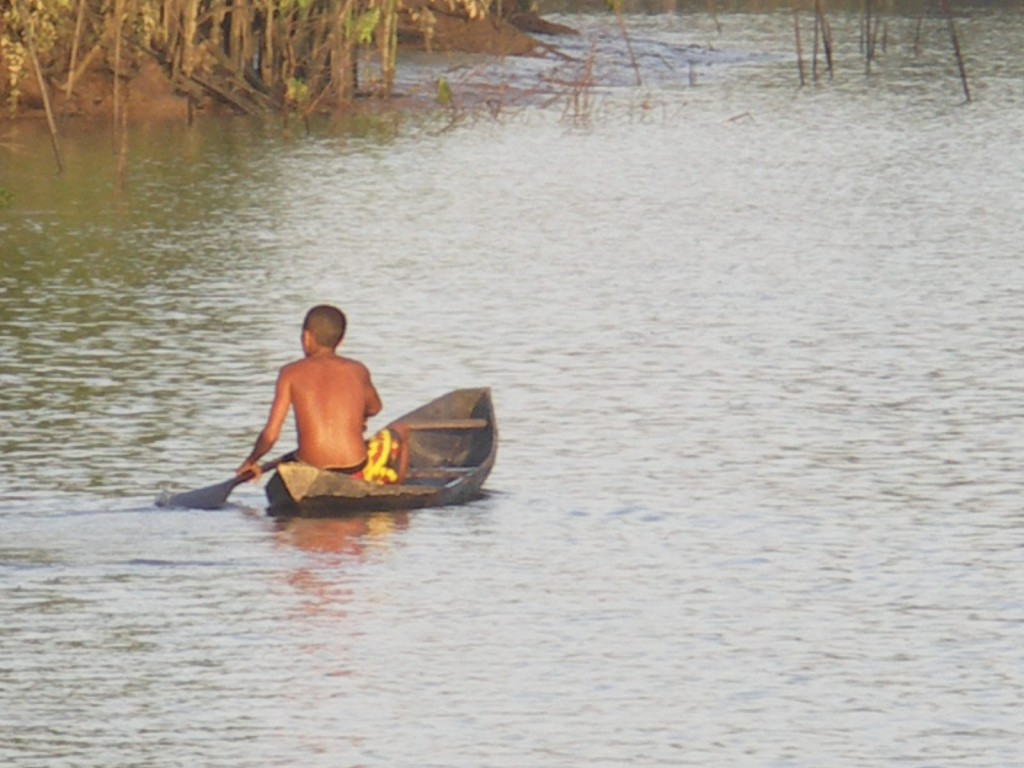 A young local native to the island of Marajó rows his canoe up the river. 