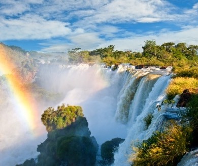 A rainbow forms over the falls of Iguacu.