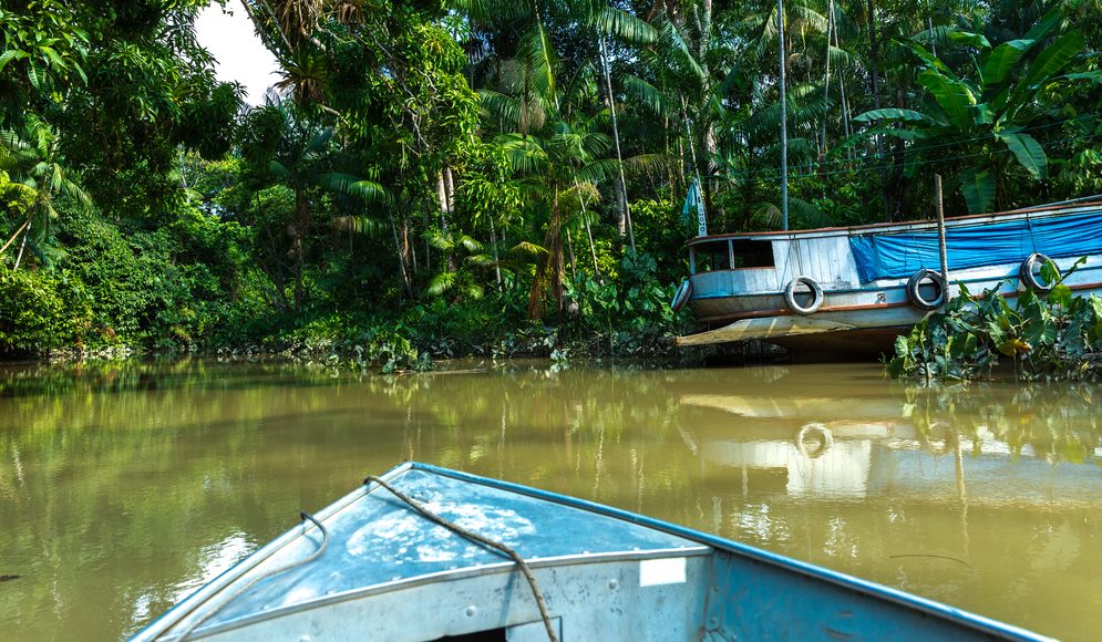 A small canoe works its way up the river. 