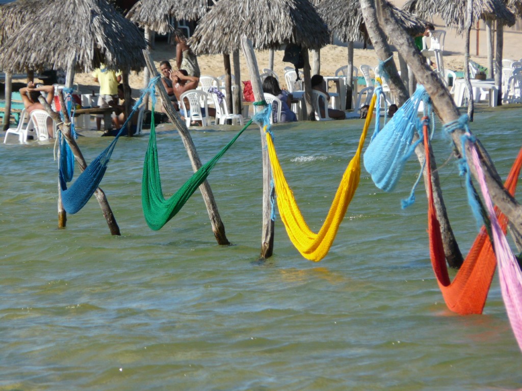Multi-coloured hammocks suspended above the warm water. 