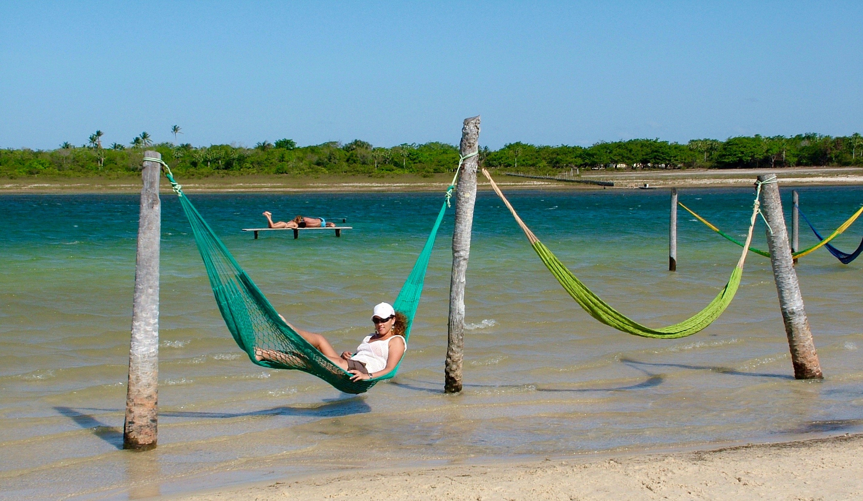 Tatajuba, some brightly coloured hammocks hang above the pleasent warm waters.