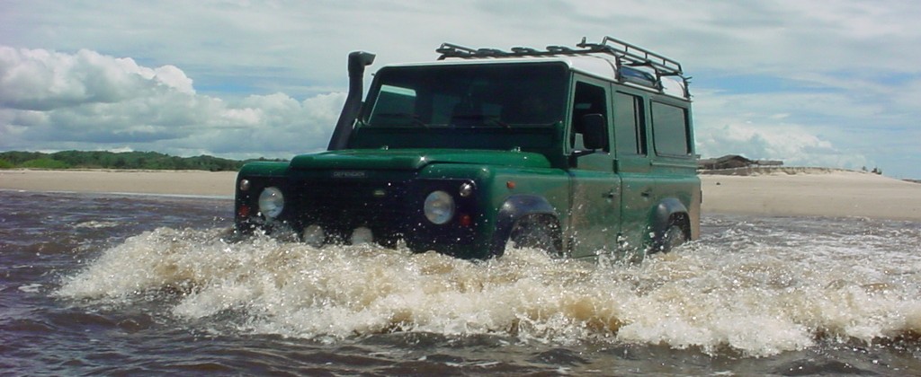 A 4x4 jeep, splashing through the water in Brazil. 