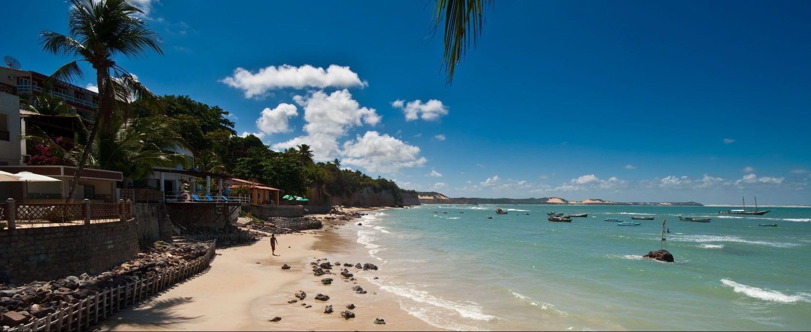 A view of Pipa beach with boats bobbing on the blue sea. 