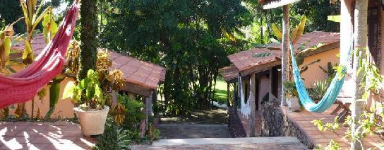 Outdoor view in the encantes de Nordeste pousada, beautiful coloured hammocks hang in the wind. 