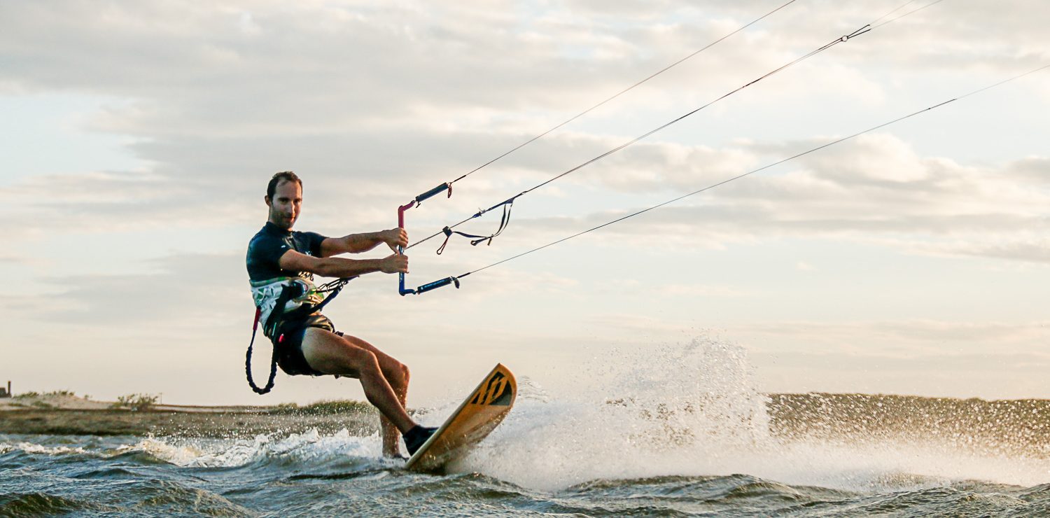 Kitesurfer rides on a surfboard style board.