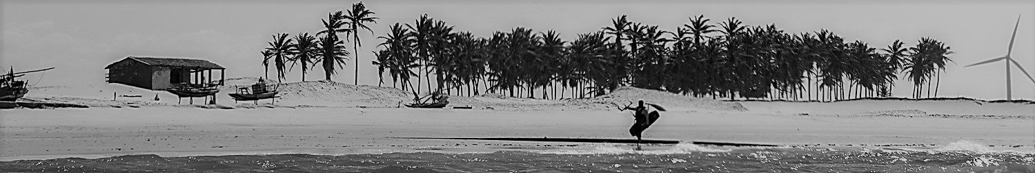 Panoramic black and white of kitesurfer riding in Brazil.