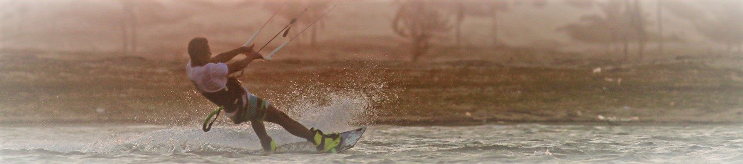 Sepia shot of kitesurfer from behind.