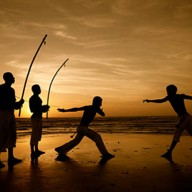 Capoeira on the beach at sunset.