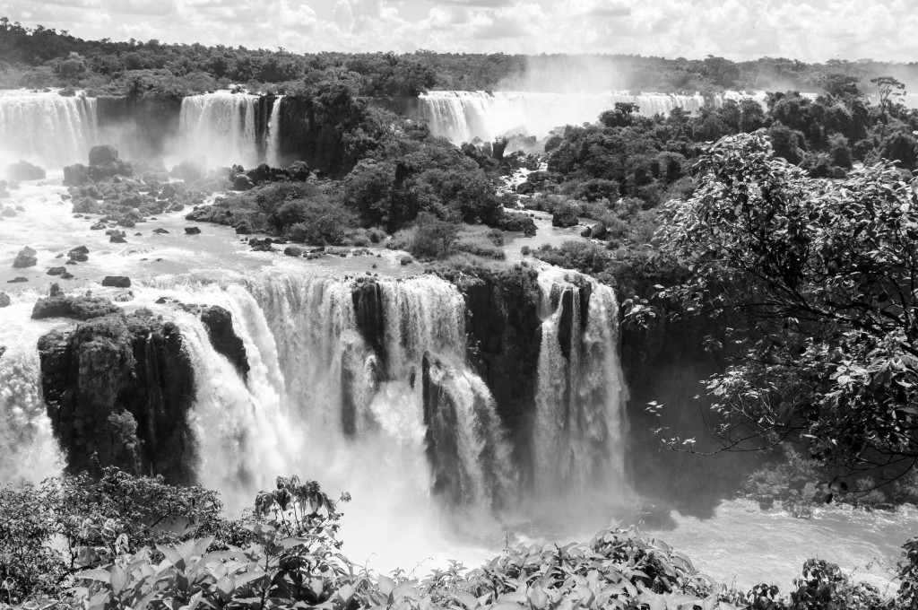 Water gushes down over the greenery at Iguaçu Falls. 