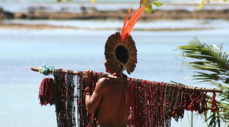 An indigenous selling jewells on the beach of Trancoso